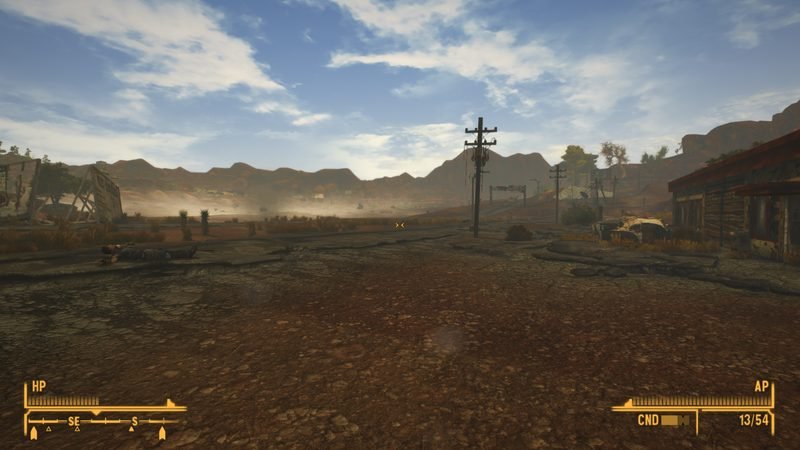 Dust haze over the Mojave in the late morning, with a body on the road and power lines receding into the distance